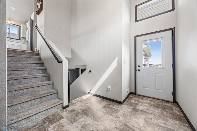 6718 69th Ave S, Horace, ND 58047 - foyer entrance with stairway, stone finish flooring, baseboards, and a towering ceiling