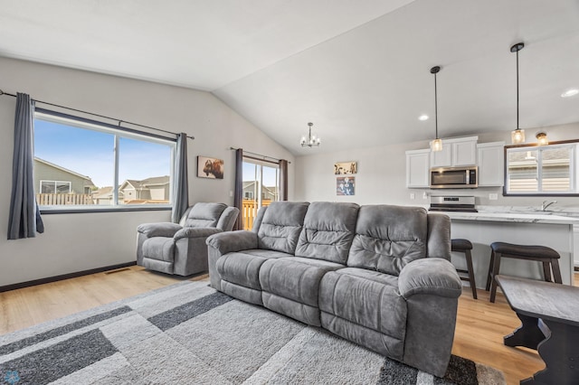 6718 69th Ave S, Horace, ND 58047 - living area featuring light wood finished floors, vaulted ceiling, a chandelier, and recessed lighting