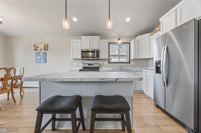 6718 69th Ave S, Horace, ND 58047 - kitchen featuring appliances with stainless steel finishes, light countertops, a center island, white cabinets, and recessed lighting