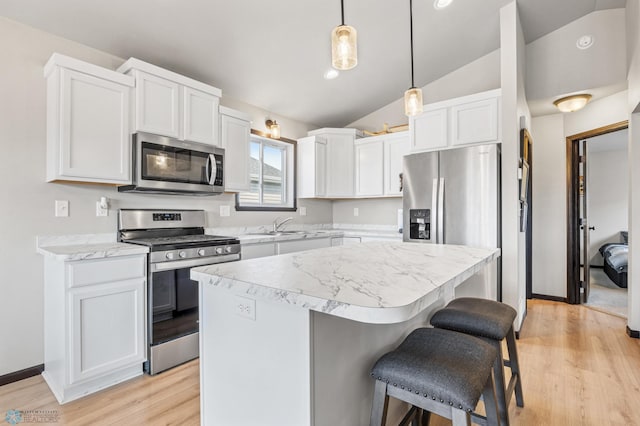 6718 69th Ave S, Horace, ND 58047 - kitchen with appliances with stainless steel finishes, lofted ceiling, a kitchen bar, a kitchen island, and white cabinetry