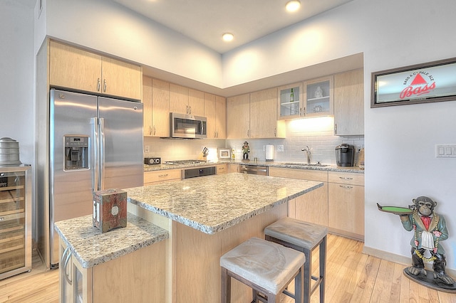 740 Portland Ave Unit 1005, Minneapolis, MN 55415 - kitchen with stainless steel appliances, light brown cabinets, a sink, beverage cooler, and recessed lighting