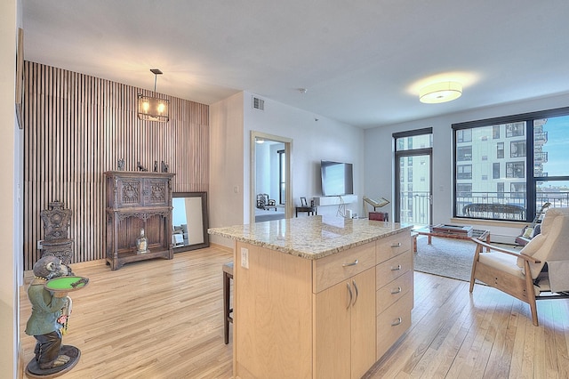 740 Portland Ave Unit 1005, Minneapolis, MN 55415 - kitchen with light wood-style floors, light brown cabinets, healthy amount of natural light, and light stone countertops