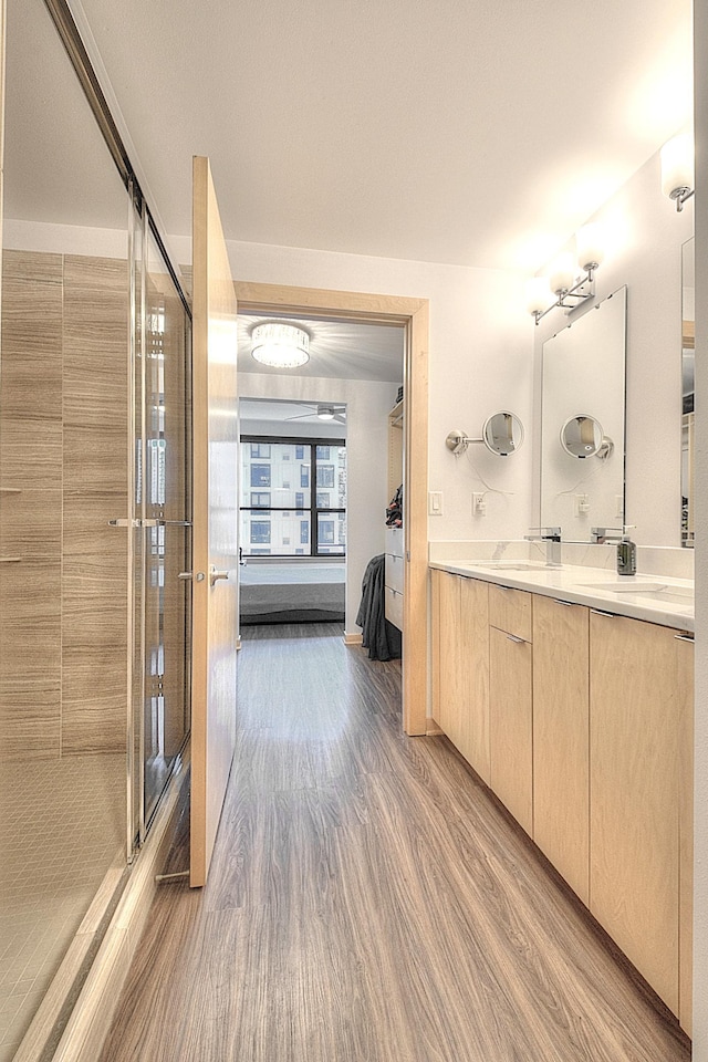 740 Portland Ave Unit 1005, Minneapolis, MN 55415 - full bathroom featuring double vanity, wood finished floors, and a stall shower