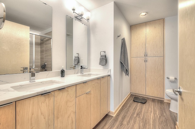 740 Portland Ave Unit 1005, Minneapolis, MN 55415 - full bath with toilet, double vanity, wood finished floors, an enclosed shower, and baseboards