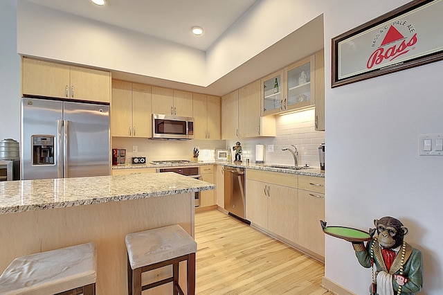 740 Portland Ave Unit 1005, Minneapolis, MN 55415 - kitchen featuring appliances with stainless steel finishes, light brown cabinets, light wood-style floors, tasteful backsplash, and recessed lighting