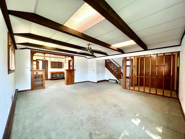 508 2nd Ave, Goodhue, MN 55027 - unfurnished living room featuring baseboards, ceiling fan, beam ceiling, stairway, and carpet