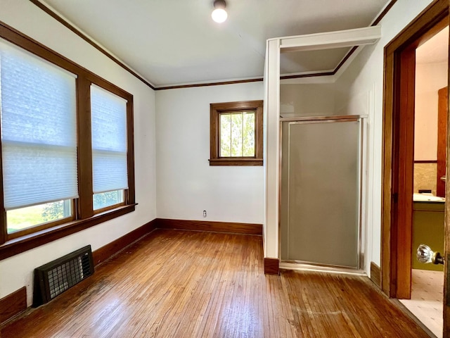 508 2nd Ave, Goodhue, MN 55027 - unfurnished bedroom with hardwood / wood-style floors, multiple windows, baseboards, a closet, and crown molding