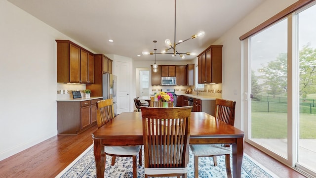 11330 Harness Rd, Woodbury, MN 55129 - dining room featuring plenty of natural light, light wood-type flooring, baseboards, recessed lighting, and a chandelier