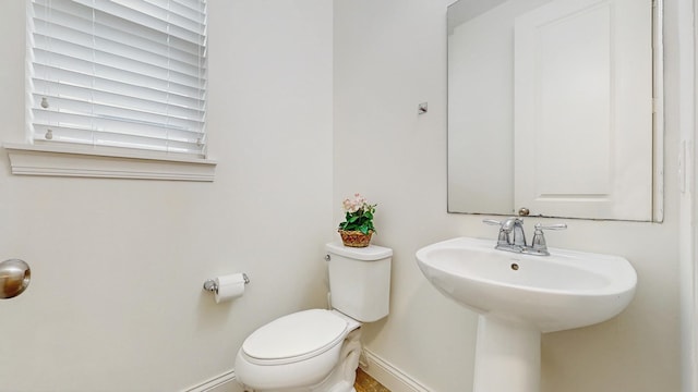 11330 Harness Rd, Woodbury, MN 55129 - bathroom featuring toilet, baseboards, and a sink