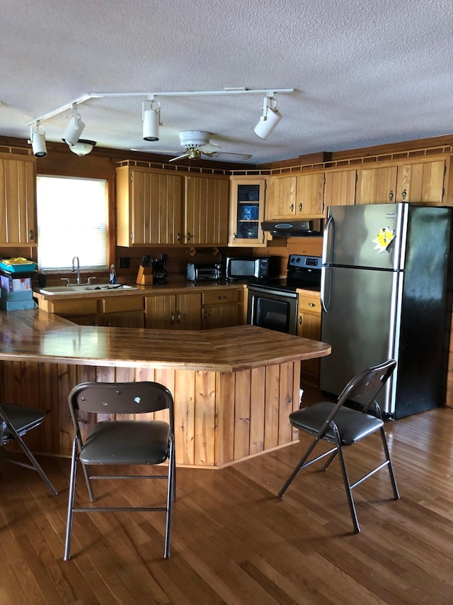 43923 Vista Rd, Isle, MN 56342 - kitchen featuring black appliances, track lighting, under cabinet range hood, a sink, and a textured ceiling