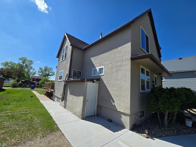 310 20th St N, Fargo, ND 58102 - view of property exterior featuring stucco siding and a yard