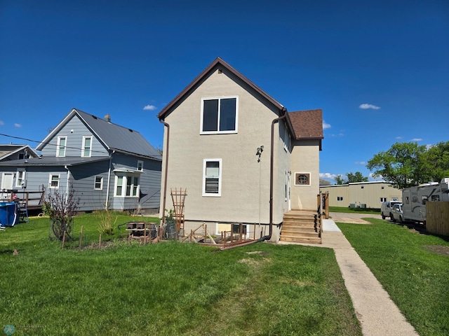 310 20th St N, Fargo, ND 58102 - rear view of house featuring a lawn and stucco siding