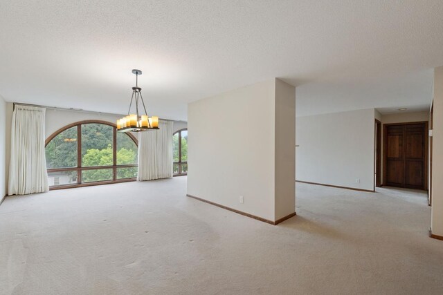 5100 France Ave S Unit 305, Edina, MN 55410 - unfurnished room with a chandelier, carpet floors, baseboards, and a textured ceiling