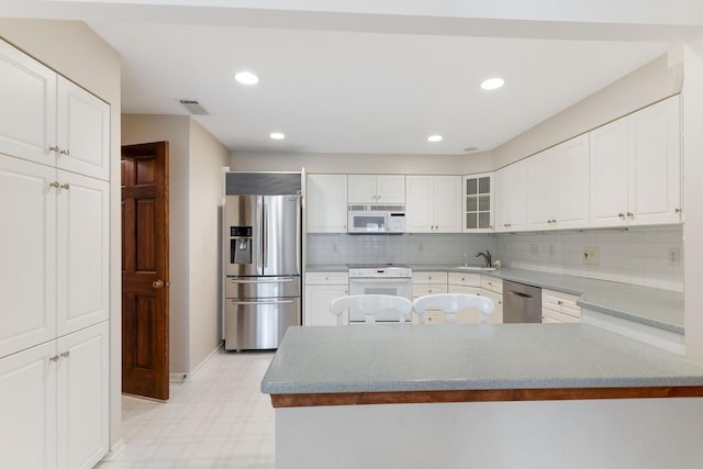 5100 France Ave S Unit 305, Edina, MN 55410 - kitchen featuring stainless steel appliances, light floors, baseboards, tasteful backsplash, and white cabinets