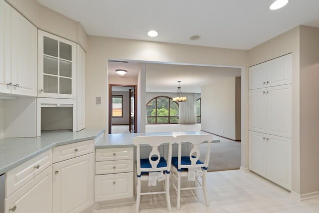 5100 France Ave S Unit 305, Edina, MN 55410 - kitchen with white cabinets, light countertops, glass insert cabinets, a peninsula, and a chandelier