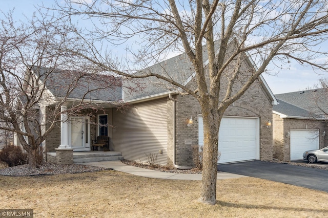 20595 Kearney Path, Lakeville, MN 55044 - view of front of house featuring driveway, brick siding, a garage, and roof with shingles