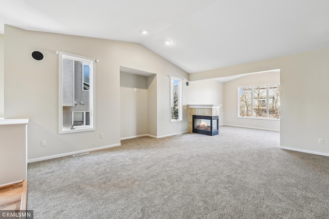 20595 Kearney Path, Lakeville, MN 55044 - unfurnished living room featuring vaulted ceiling, carpet floors, a tiled fireplace, and baseboards