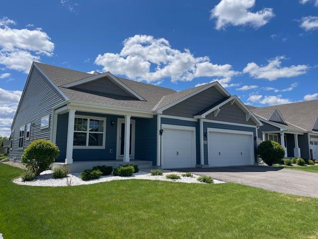 18053 Gleaming Ct, Lakeville, MN 55044 - ranch-style house featuring a porch, an attached garage, a front yard, asphalt driveway, and a shingled roof