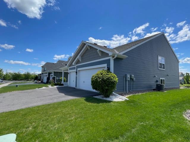 18053 Gleaming Ct, Lakeville, MN 55044 - view of side of property with a lawn, asphalt driveway, and a garage