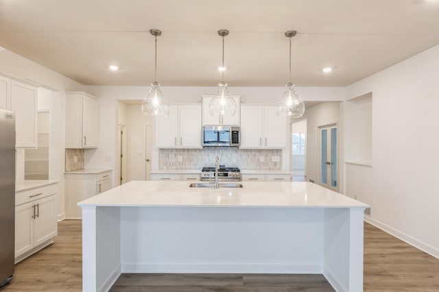 9729 49th St NE, Saint Michael, MN 55376 - kitchen featuring appliances with stainless steel finishes, decorative backsplash, an island with sink, white cabinetry, and recessed lighting
