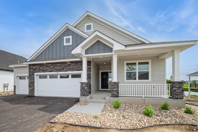 9729 49th St NE, Saint Michael, MN 55376 - craftsman inspired home with covered porch, board and batten siding, asphalt driveway, and stone siding