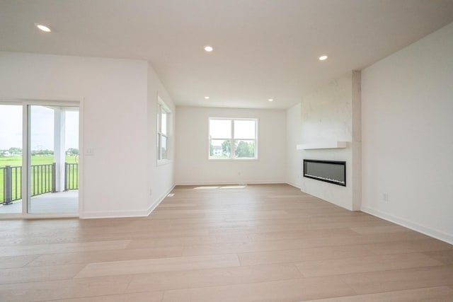 9729 49th St NE, Saint Michael, MN 55376 - unfurnished living room featuring light wood-style floors, recessed lighting, and a large fireplace