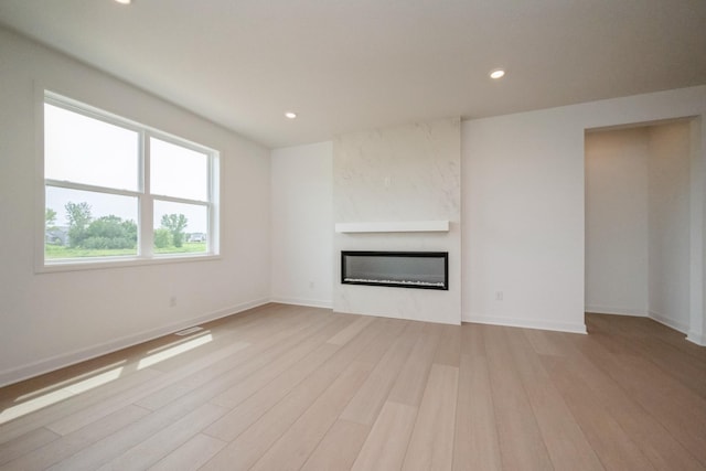9729 49th St NE, Saint Michael, MN 55376 - unfurnished living room with a large fireplace, light wood-style floors, and recessed lighting