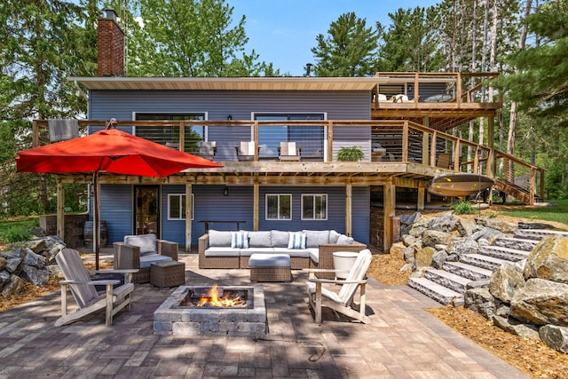 2625 7th Ave, Chetek, WI 54728 - back of house featuring an outdoor living space with a fire pit, a chimney, a deck, and a patio