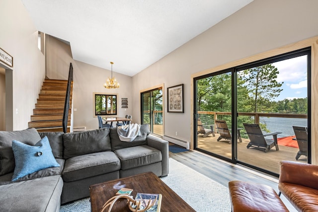 2625 7th Ave, Chetek, WI 54728 - living area featuring baseboard heating, a chandelier, vaulted ceiling, stairs, and wood finished floors
