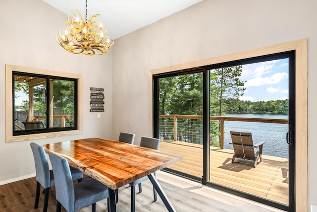 2625 7th Ave, Chetek, WI 54728 - dining room with wood finished floors, a chandelier, a water view, healthy amount of natural light, and high vaulted ceiling
