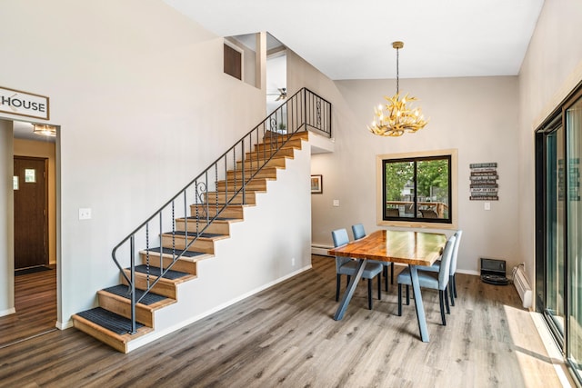 2625 7th Ave, Chetek, WI 54728 - dining space with stairway, wood finished floors, a chandelier, baseboards, and a towering ceiling