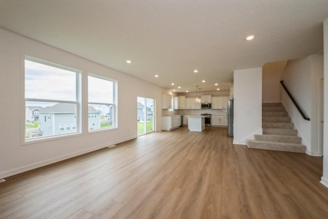 535 Rolling Hills Ln, Delano, MN 55328 - unfurnished living room with light wood-type flooring, recessed lighting, and stairs