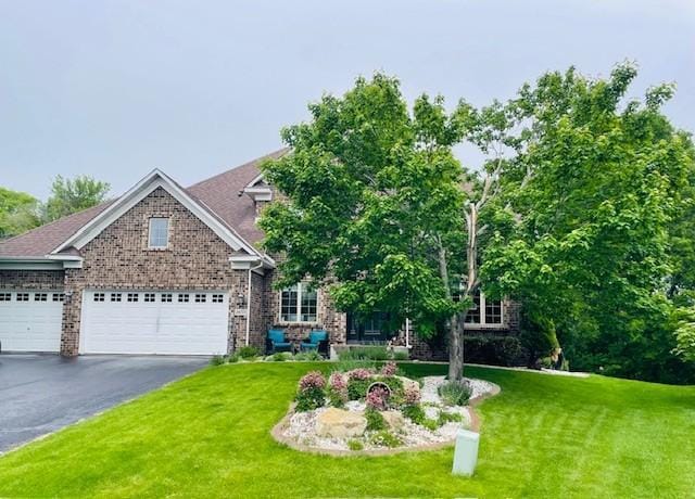14075 45th Ct NE, Saint Michael, MN 55376 - view of front of house featuring a front yard, brick siding, asphalt driveway, and a garage