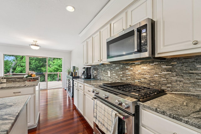 14075 45th Ct NE, Saint Michael, MN 55376 - kitchen with appliances with stainless steel finishes, ornamental molding, white cabinets, tasteful backsplash, and dark wood-type flooring