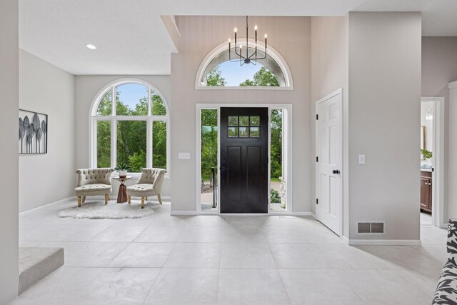 17032 Valley Dr NW, Andover, MN 55304 - entryway featuring a chandelier, a towering ceiling, light tile patterned floors, and baseboards
