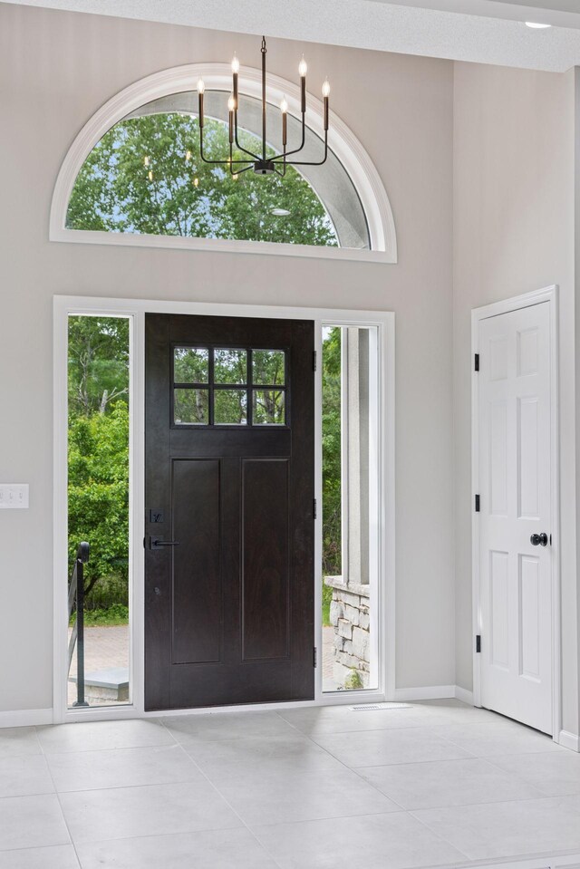 17032 Valley Dr NW, Andover, MN 55304 - entrance foyer featuring tile patterned flooring, baseboards, and a chandelier