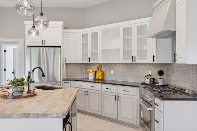 17032 Valley Dr NW, Andover, MN 55304 - kitchen with stainless steel appliances, premium range hood, a sink, decorative backsplash, and white cabinets