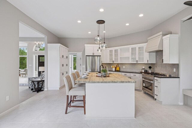 17032 Valley Dr NW, Andover, MN 55304 - kitchen featuring stainless steel appliances, custom range hood, healthy amount of natural light, tasteful backsplash, and recessed lighting