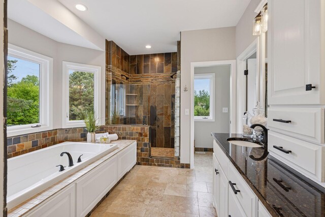 17032 Valley Dr NW, Andover, MN 55304 - bathroom featuring a shower stall, a garden tub, vanity, stone tile floors, and baseboards