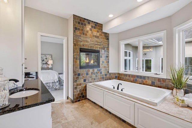17032 Valley Dr NW, Andover, MN 55304 - ensuite bathroom featuring vanity, a garden tub, recessed lighting, tile walls, and a fireplace