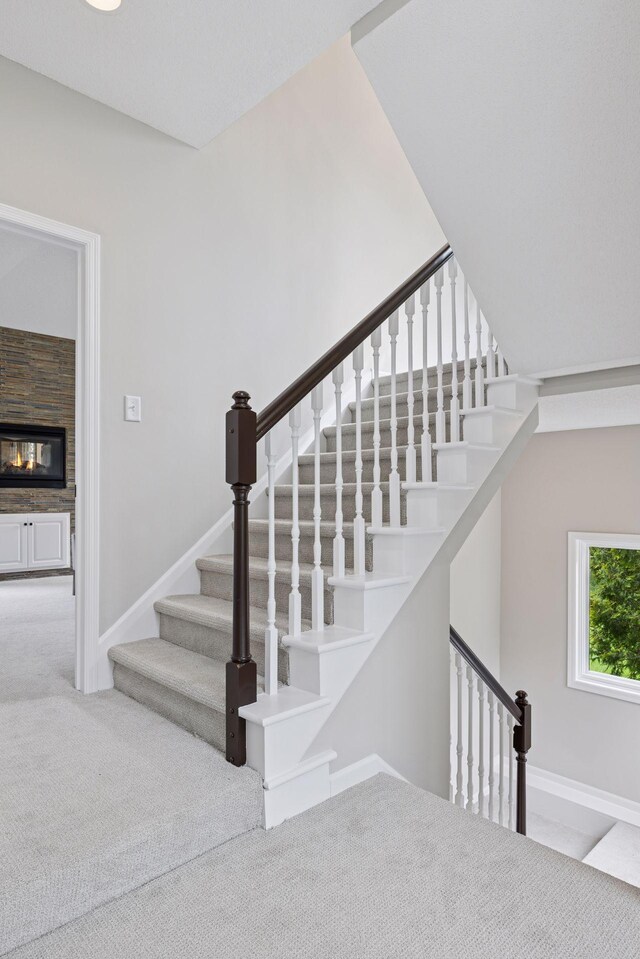 17032 Valley Dr NW, Andover, MN 55304 - stairs with carpet flooring, baseboards, and a multi sided fireplace