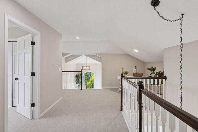 17032 Valley Dr NW, Andover, MN 55304 - hall with an upstairs landing, carpet flooring, baseboards, lofted ceiling, and a chandelier
