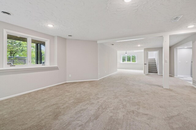 17032 Valley Dr NW, Andover, MN 55304 - empty room featuring carpet floors, a textured ceiling, baseboards, stairway, and recessed lighting