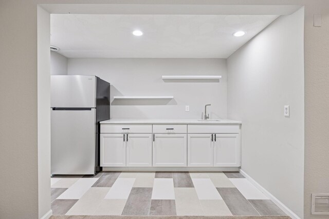17032 Valley Dr NW, Andover, MN 55304 - kitchen with freestanding refrigerator, white cabinetry, a sink, light countertops, and recessed lighting