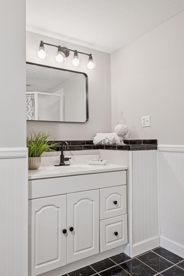 17032 Valley Dr NW, Andover, MN 55304 - bathroom featuring a wainscoted wall, vanity, granite floors, and a textured ceiling