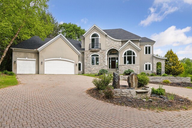 17032 Valley Dr NW, Andover, MN 55304 - french provincial home featuring stone siding, stucco siding, decorative driveway, and a garage