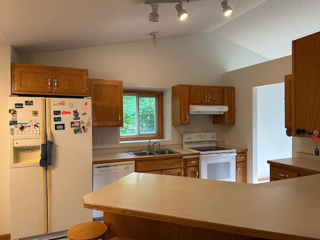 6501 Douglas Dr N, Brooklyn Park, MN 55429 - kitchen with white appliances, under cabinet range hood, vaulted ceiling, track lighting, and brown cabinets