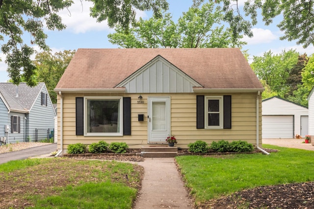 3350 Virginia Ave S, Saint Louis Park, MN 55426 - bungalow-style home with board and batten siding, a garage, an outbuilding, roof with shingles, and a front lawn