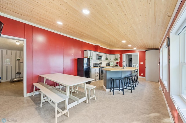 3022 Sandy Beach Rd, Hatton, ND 58240 - kitchen featuring appliances with stainless steel finishes, wood ceiling, light countertops, a center island with sink, and a breakfast bar area