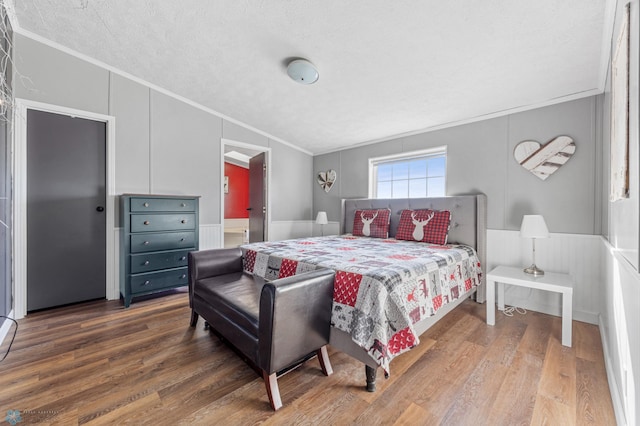 3022 Sandy Beach Rd, Hatton, ND 58240 - bedroom with crown molding, wood finished floors, a decorative wall, a textured ceiling, and wainscoting